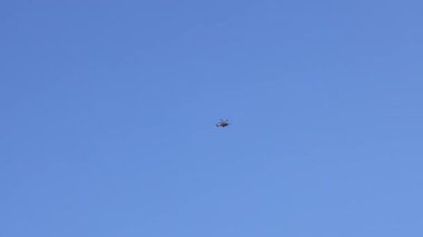 Açık mavi gökyüzünde uçan bir helikopter