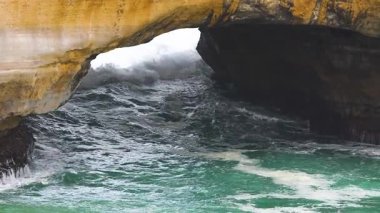 Dinamik okyanus dalgaları Londra Köprüsü 'ndeki doğal kemer yolunda, Port Campbell' da, yumuşak gün ışığında, doğanın gücünü gösteriyor.