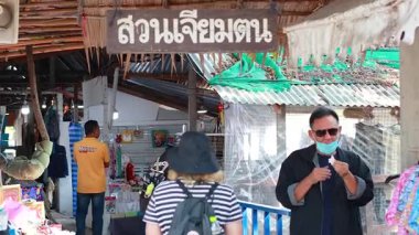 Ziyaretçiler hareketli bir pazarda alışveriş yapmayı severler