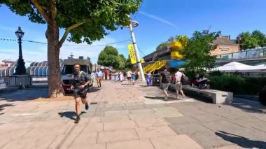 İnsanlar yemek kamyonunun ve eğlencelerin yanında yürüyorlar.