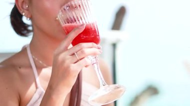 Karpuz suyunu pipetle yudumlayan bir kadın.