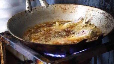 Gaz sobasında yağda kızaran balıklar.