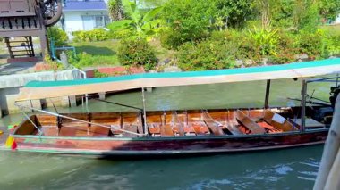 Geleneksel bir kanal teknesi, Bangkok 'taki canlı Khlong Lat Mayom Yüzen Pazarı' nda yerel kültür ve ticareti gözler önüne seriyor.