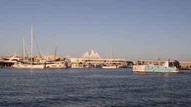 Tekneler sakin bir marina sahnesinde ilerler.