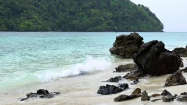 Dalgalar yavaşça Krabi 'nin kayalık kıyısına çarpıyor.