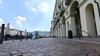 Üstü örtülü nesneler ve binalarla dolu bir kaldırım taşı caddesi
