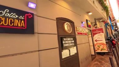 İnsanlar cadde kenarındaki bir lokantada pizza yemekten hoşlanıyorlar.