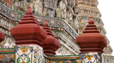 Wat Arun 'un Bangkok' taki detaylı mimarisini gösteren bir video, doğal gün ışığı altında süslü heykeller ve canlı renkler yer alıyor.