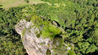 İnsansız hava aracı görüntüleri, yoğun okaliptüs ormanlarıyla çevrili Nimbin Kayalarını parlak gün ışığında yakalıyor ve doğal güzellikleri ve jeolojik oluşumları gözler önüne seriyor.