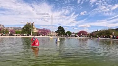 Paris bahçe çeşmesinde yüzen oyuncak yelkenliler