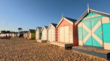 Batan güneşli renkli sahil kulübeleri