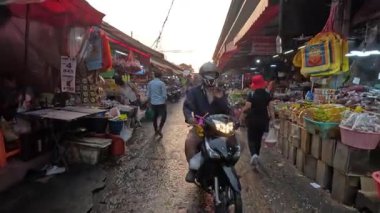 Kalabalık bir açık hava pazarında müşteriler ve satıcılar