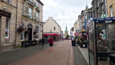 İnsanlar işlek bir alışveriş caddesinde yürüyor