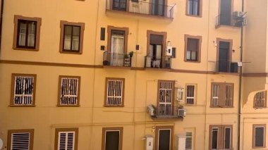 Balkonlu ve pencereli sarı bina