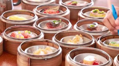 Canlı bir Dim Sum sepetleri sergileniyor ve hareketli bir Phuket lokantasında servis ediliyor.