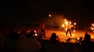 Göstericiler plajda ateş yeteneğini sergilerler.