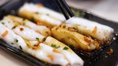 Çubuklar soslu pirinç eriştesi topluyor.