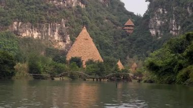 Yeşillik ve nehrin ortasındaki kulübe ve köprü