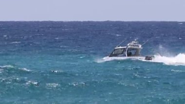 Sürat teknesi okyanusta dalgaları kesiyor.