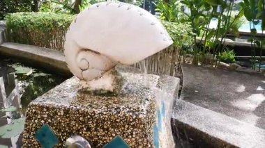 Kabuk şeklindeki taş çeşmeden akan su.