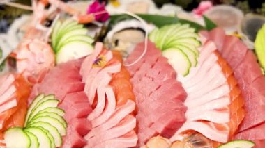 Çeşitli suşi ve deniz ürünleri bir tabakta sergilenir.