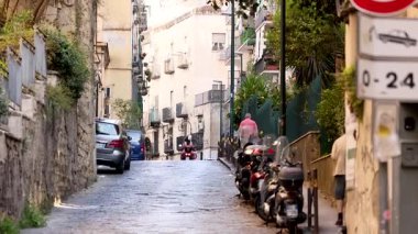 Dar bir sokakta insanlar ve araçlar