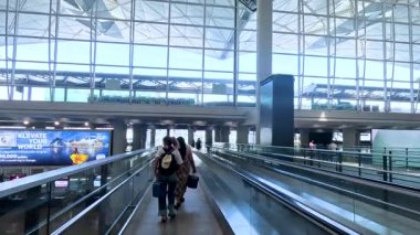 Hong Kong havaalanındaki insanlar yürüyüş yolunu kullanıyor.