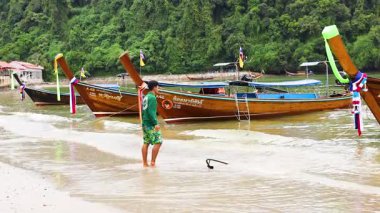 Tekneler ve insanlar Krabi 'nin kıyı şeridinde etkileşime geçiyor.