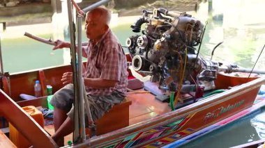 Adam hareketli yüzen pazarda tekneyi yüzdürüyor.