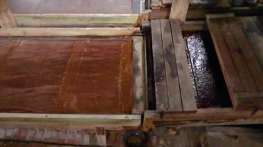 Tahta kalaslar geleneksel bir kereste fabrikasında hareket ederek mekanik süreci doğal ışıklandırma ile tarihi bir ortamda sergiliyor.