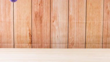 Ahşap bir yüzeyde mor bir top zıplar.