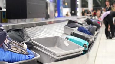 Taşıma bandından çantaları alan yolcular