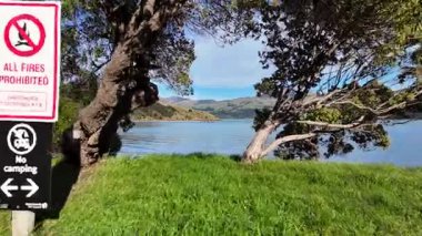 Bereketli yeşillik ve açık mavi gökyüzünün altındaki dağlarla çevrili Akaroa Gölü 'nün sakin bir havası.