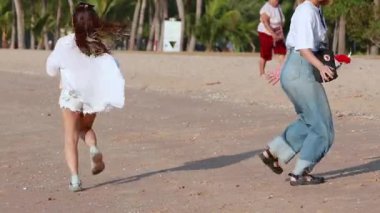 Genç kız sevinçle kumsalda koşar