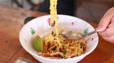 Erişteleri çubuklarla ve kaşıkla karıştırıyorum.