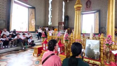Bangkok Şehir Sütun Tapınağı 'nda dingin bir tören düzenlenirken, geleneksel kıyafetler ve canlı dekorasyonlar kutsal bir ortamda sergileniyor.