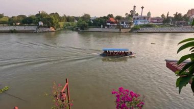 Bir tekne manzaralı bir nehir manzarasında yol alır.