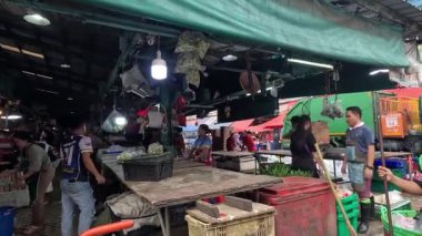 İşçiler kalabalık bir pazar alanını temizliyorlar