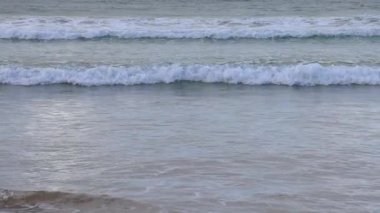 Dalgalar Büyük Okyanus Yolu 'nda kıyıya vuruyor. Yumuşak, doğal ışık altında sakin bir atmosferle çekiliyor.