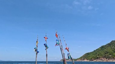 Tayland 'ın Phuket yakınlarındaki sularda bir tekne geziniyor, açık gökyüzü altında aksiyona hazır olmalarını sağlayan oltalarla.