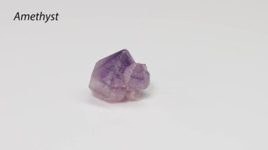 Ametist kristali beyaz arkaplanda dönüyor