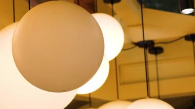 Işığı yansıtan küresel lambalar aynalı bir alanda