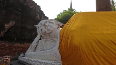 Kumaş yavaş yavaş Buda heykelinden çıkarıldı.