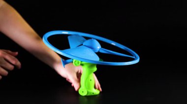 Oyuncak helikopteri çekme mekanizması kullanarak elle fırlatır