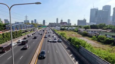 Araçlar çok şeritli bir otoyolda ilerliyor.