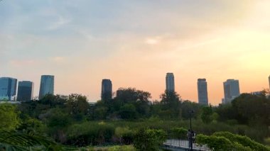 Şehir silueti ve parkı olan günbatımı manzarası