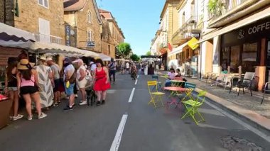 İnsanlar canlı bir sokak pazarının keyfini çıkarıyorlar.