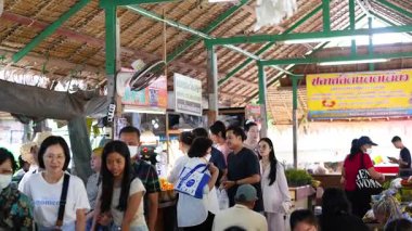 Ziyaretçiler kalabalık bir pazarda alışverişin keyfini çıkarıyorlar