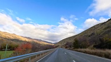 Wanaka 'nın göz kamaştırıcı dağlık arazisinde 12 saniyelik bir yolculuk. Parlak mavi bir gökyüzünün altında, dağınık bulutlarla.