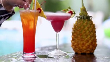 İçecekler tazeleniyor ve havuz kenarında ananas var.